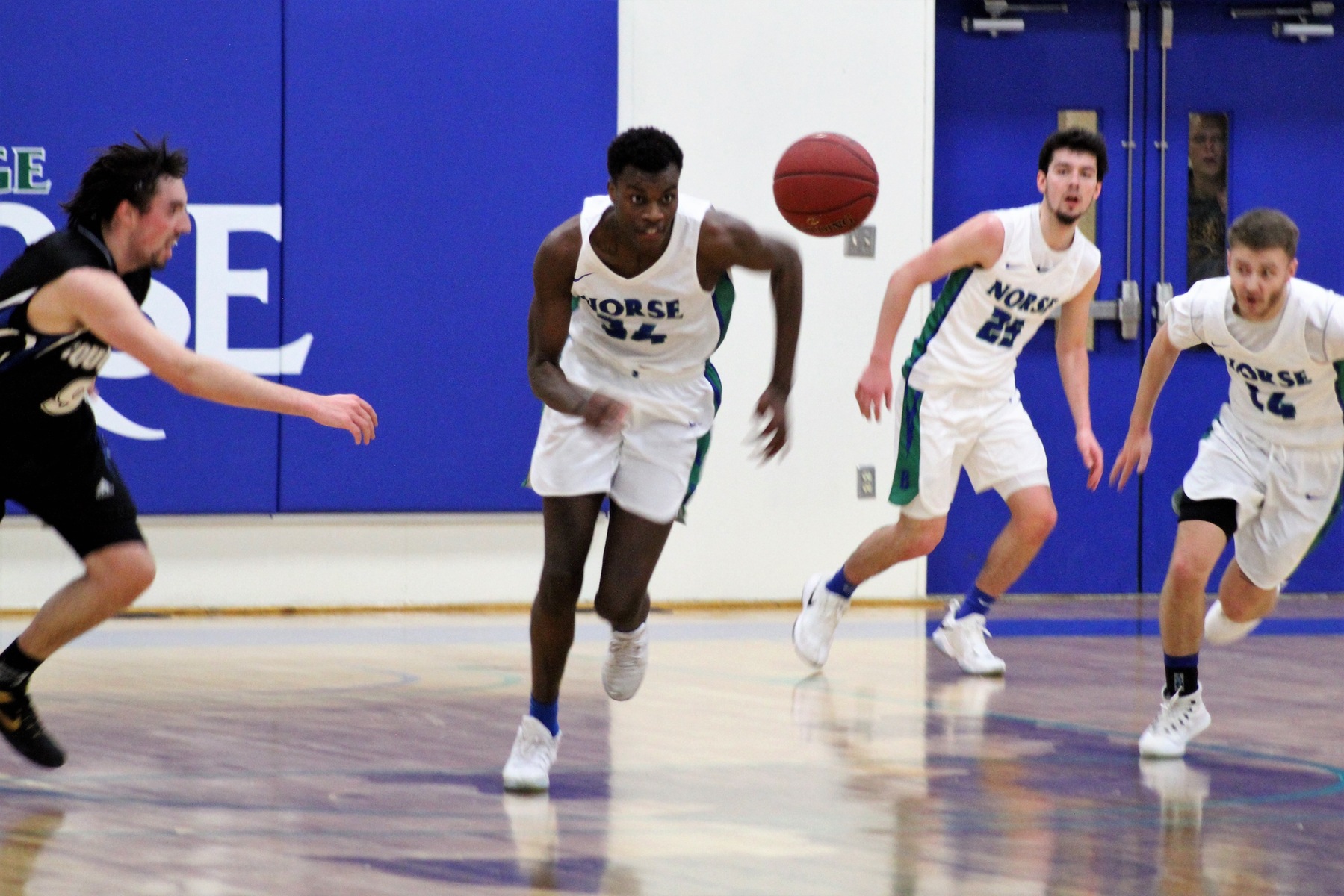 Kobi Barnes chasing a loose ball, Garret Finkbeiner and Dre Touminen look on in the background