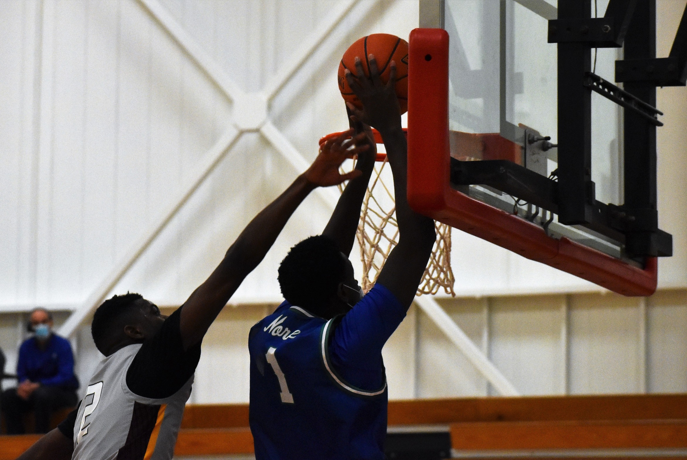 Jibril Ndiaye going up for a dunk as a defender reaches from behind him