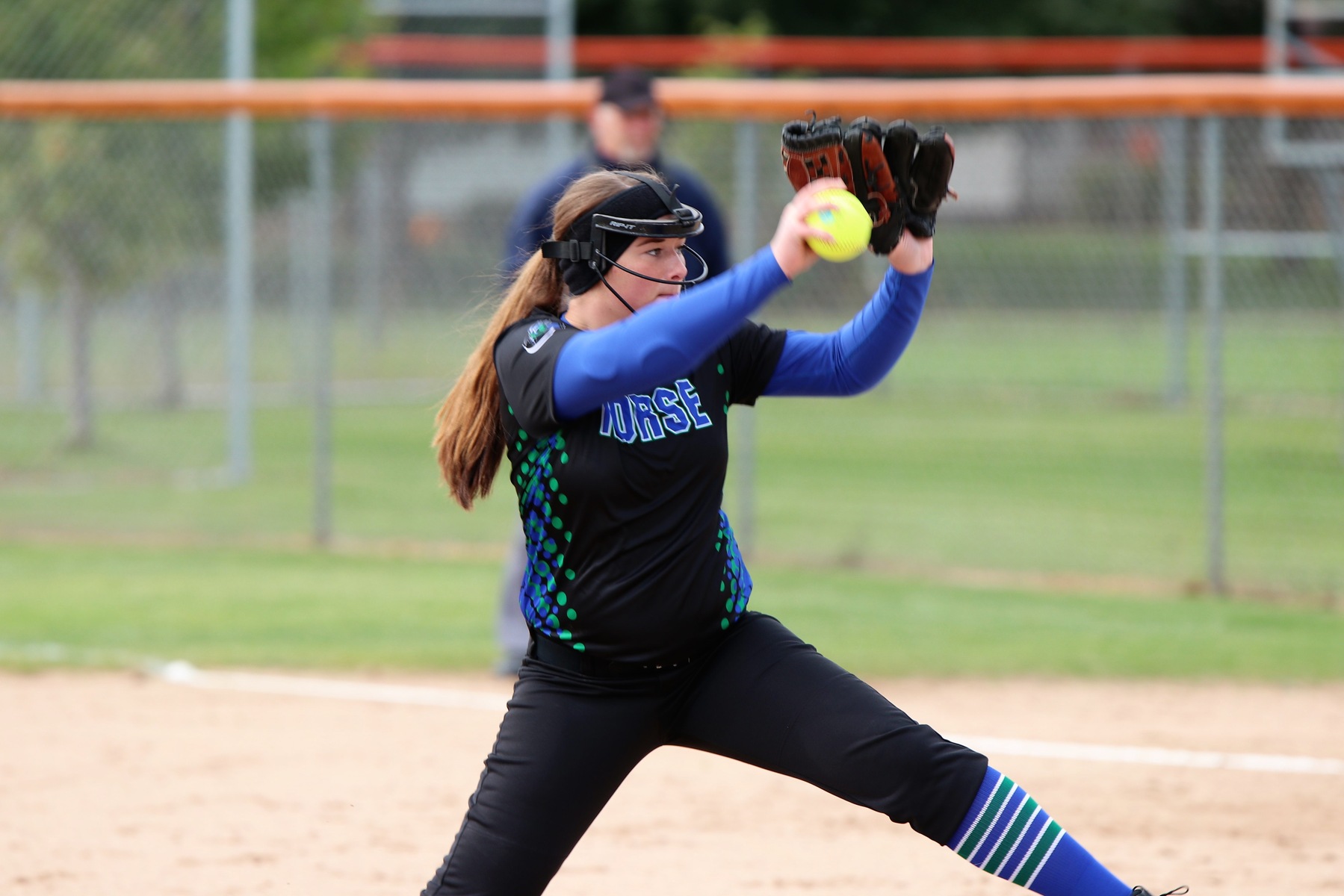 Lexi Winling bringing the ball above her head in her pitching motion