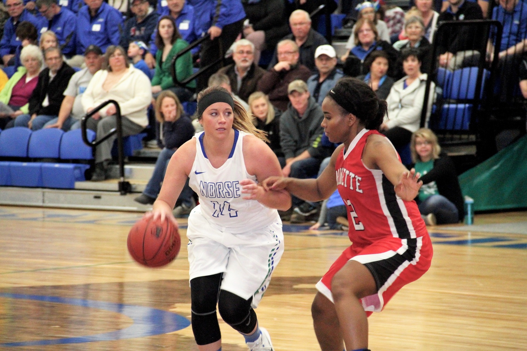 Caitlin Hewitt dribbling to her right with a defender closely guarding