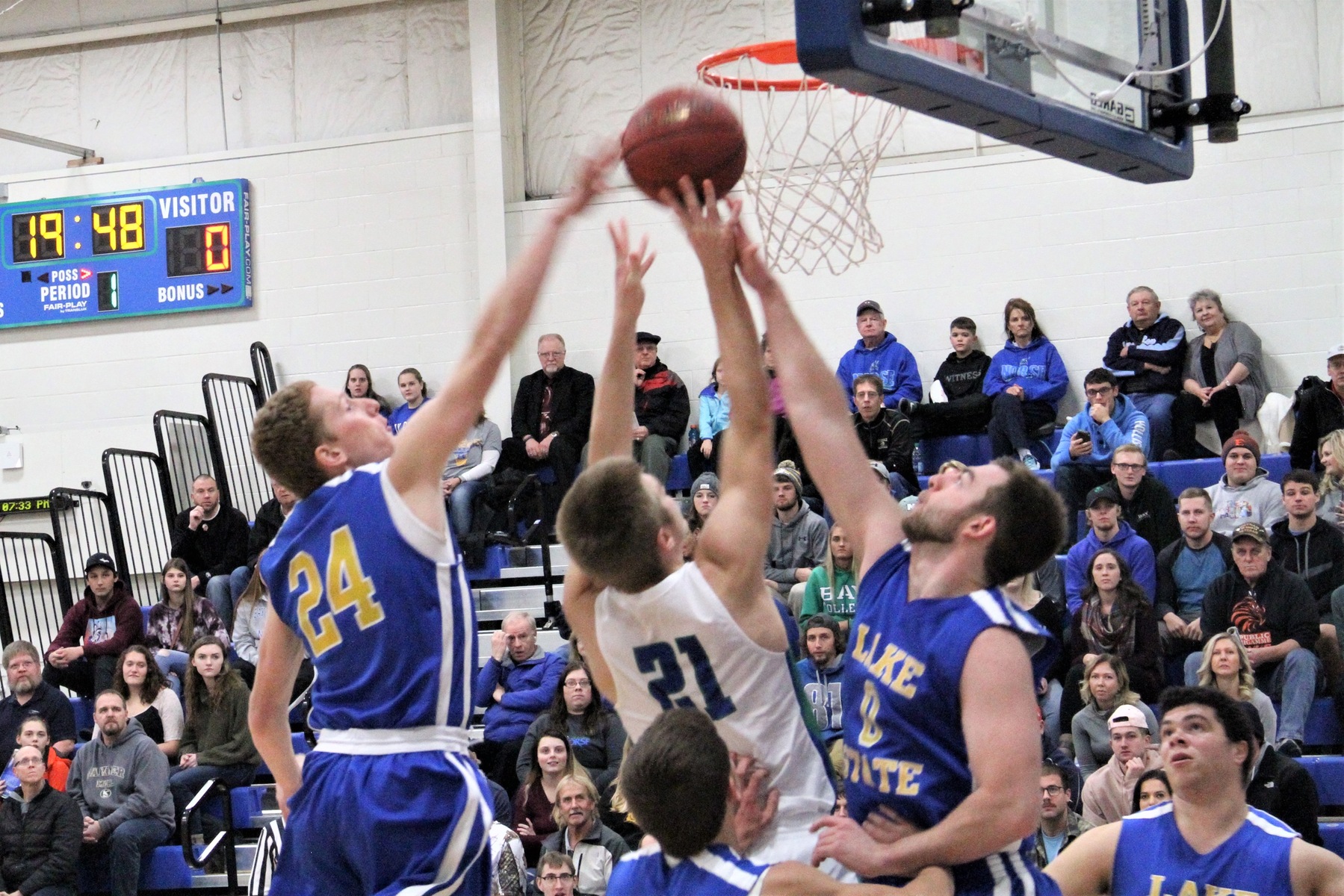 Tyler Willette releases a shot near the rim as two defenders reach trying to block his attempt