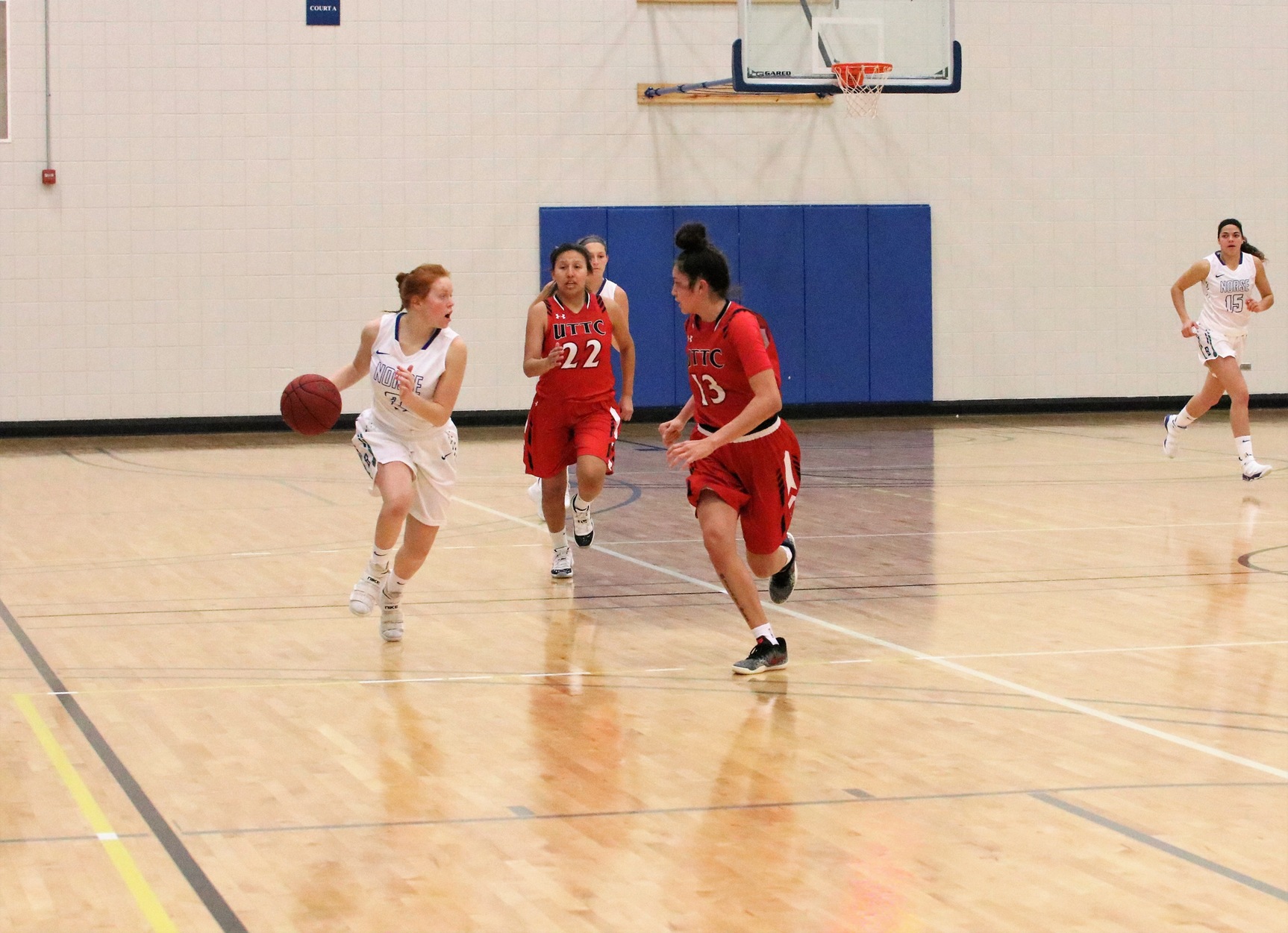JuliAnn Wickman brings the ball up the sideline, two defenders close in