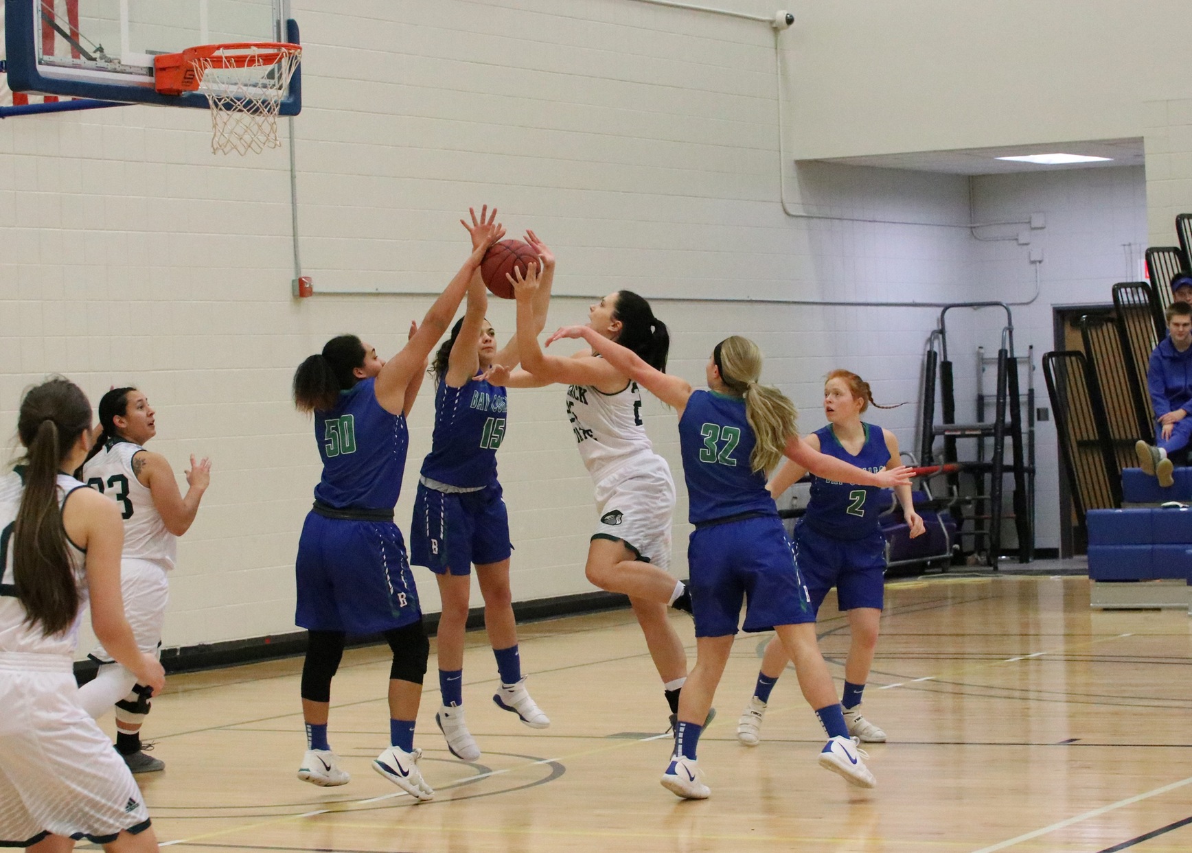 Keshia Davis has a hand on a defenders shot in the lane, as Brooke Dalgord is closely by, also about to block the attempt.