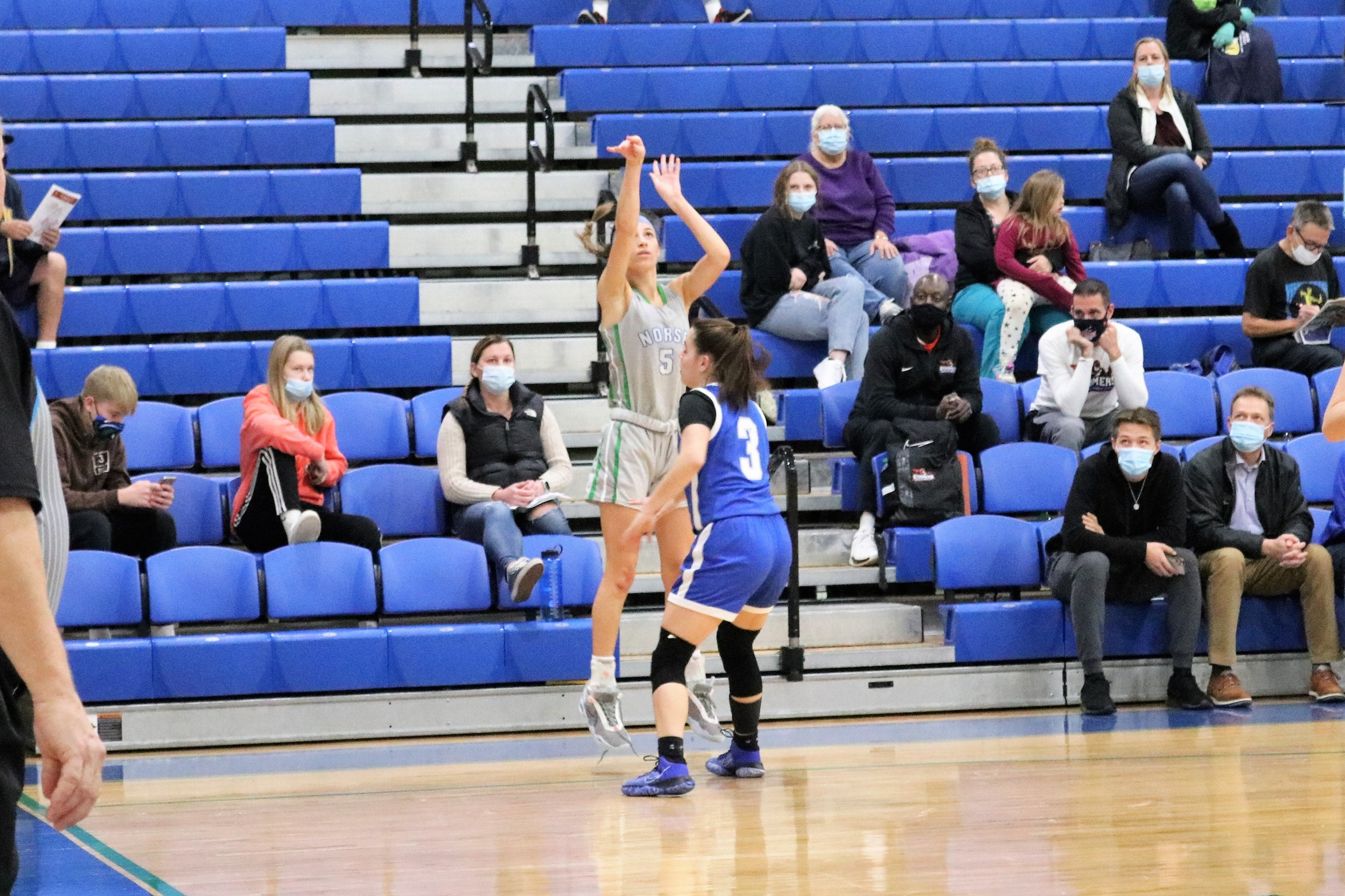 Kennedy Englund releasing a three-pointer from the corner as a defender closes in