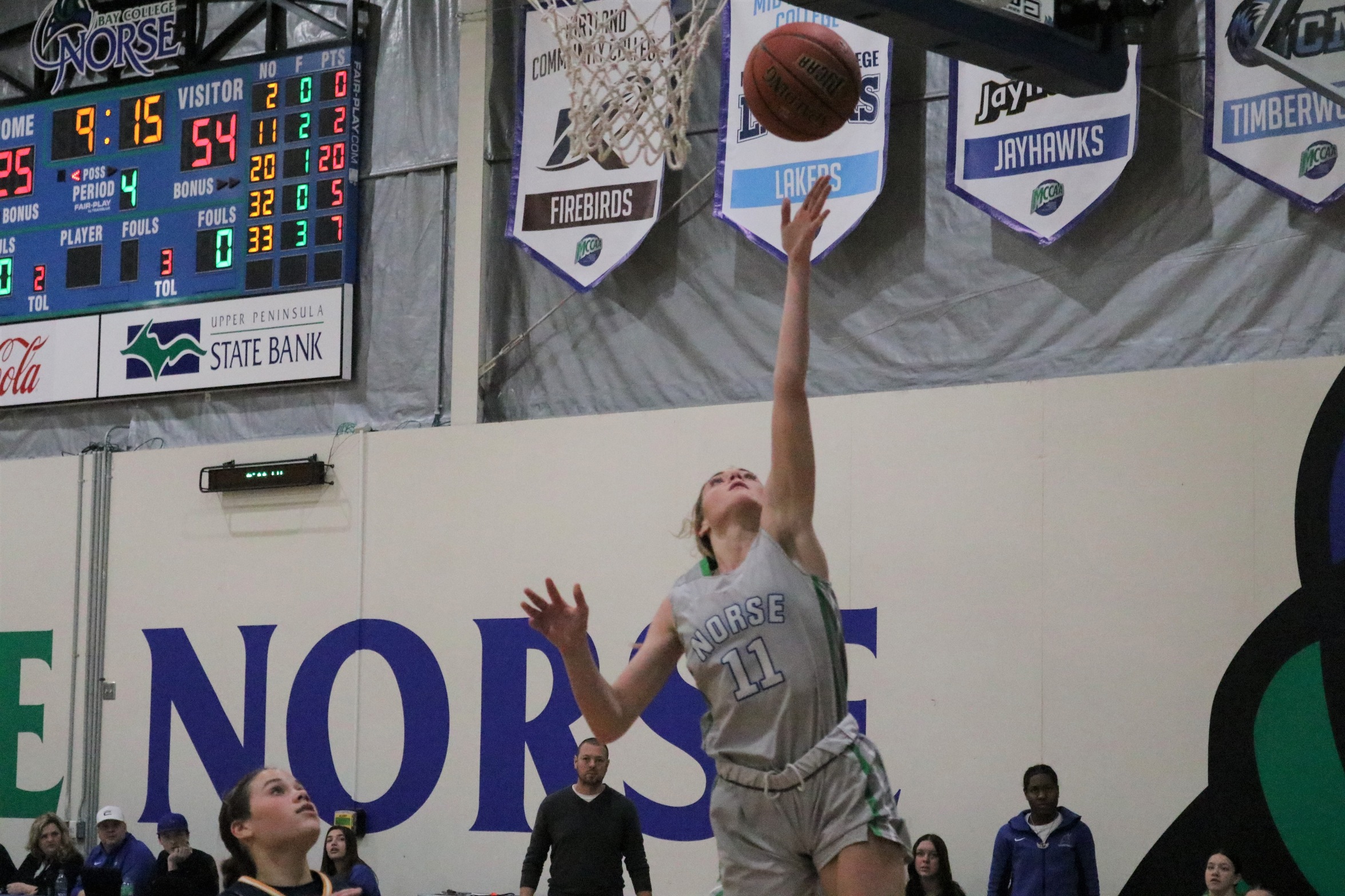 Alyssa Cretton watches with an outstretched hand as the layup she has just released goes up towards the basket