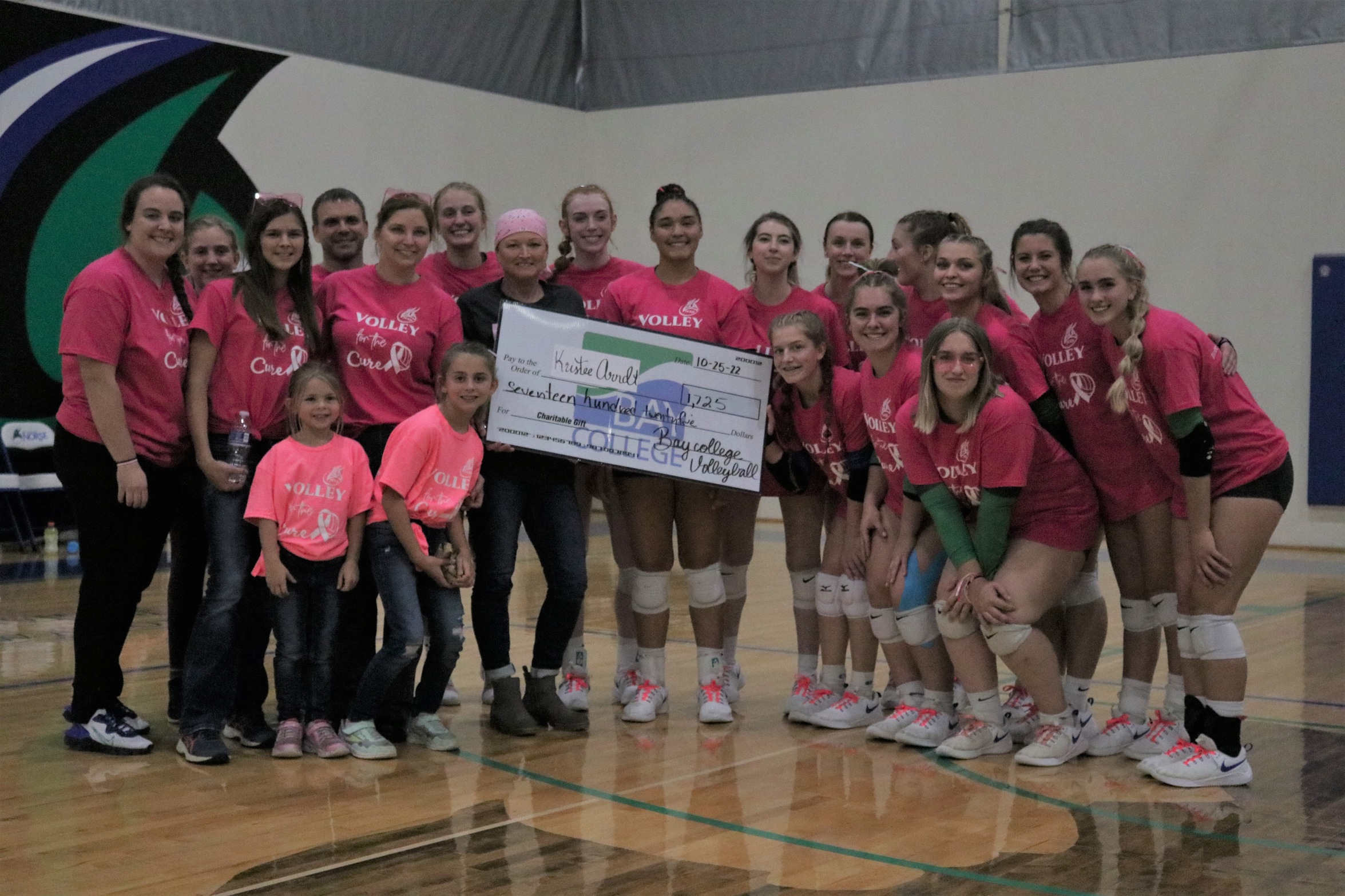 The Norse Volleyball team poses with Kristee Arndt and a ceremonial check indicating the amount raised in the evening's event.