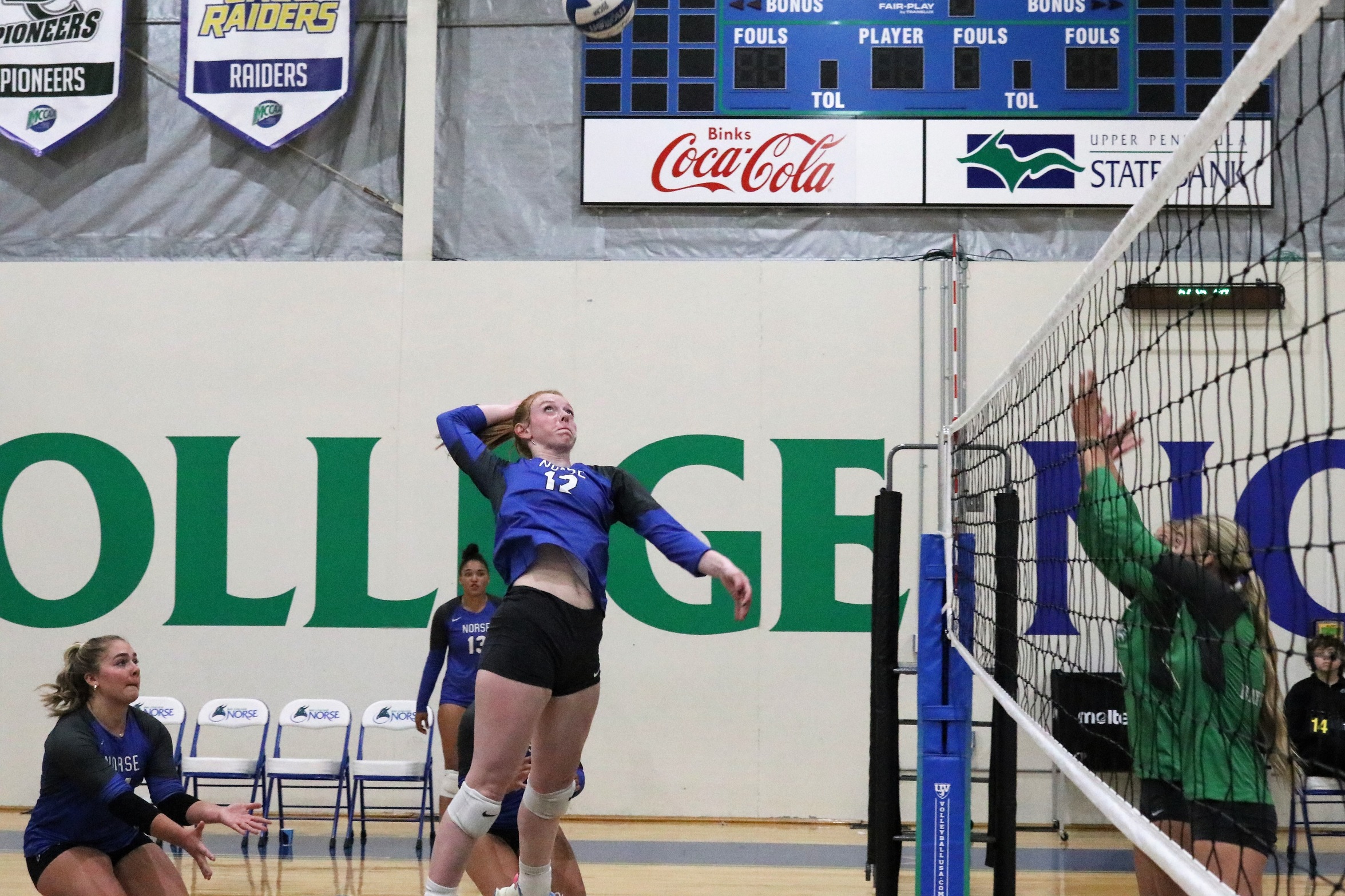 Kylee Tadisch goes up for a kill attempt as teammates look on