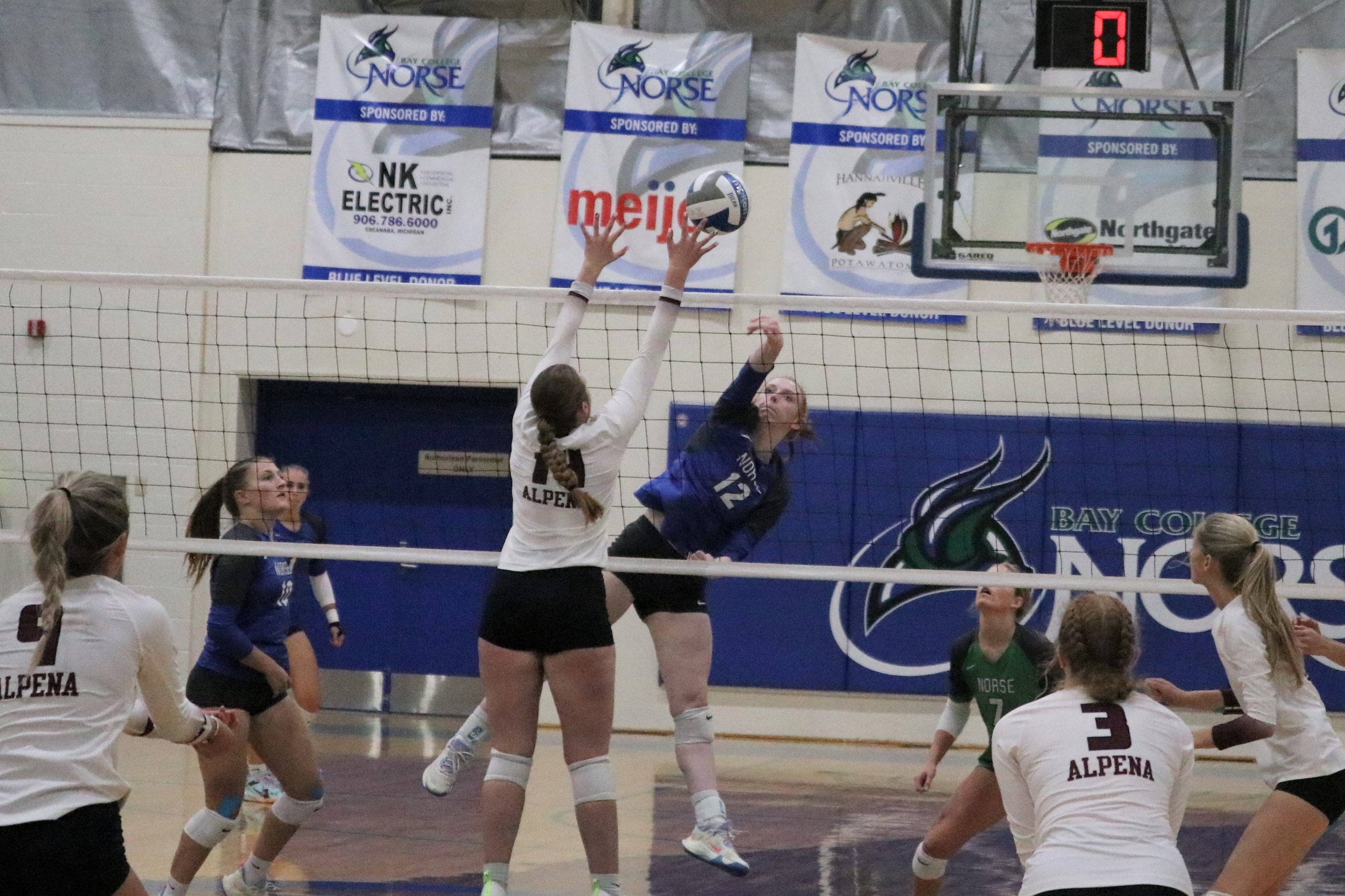 Kylee Tadisch with a kill attempt as an opposing player attempts to block it