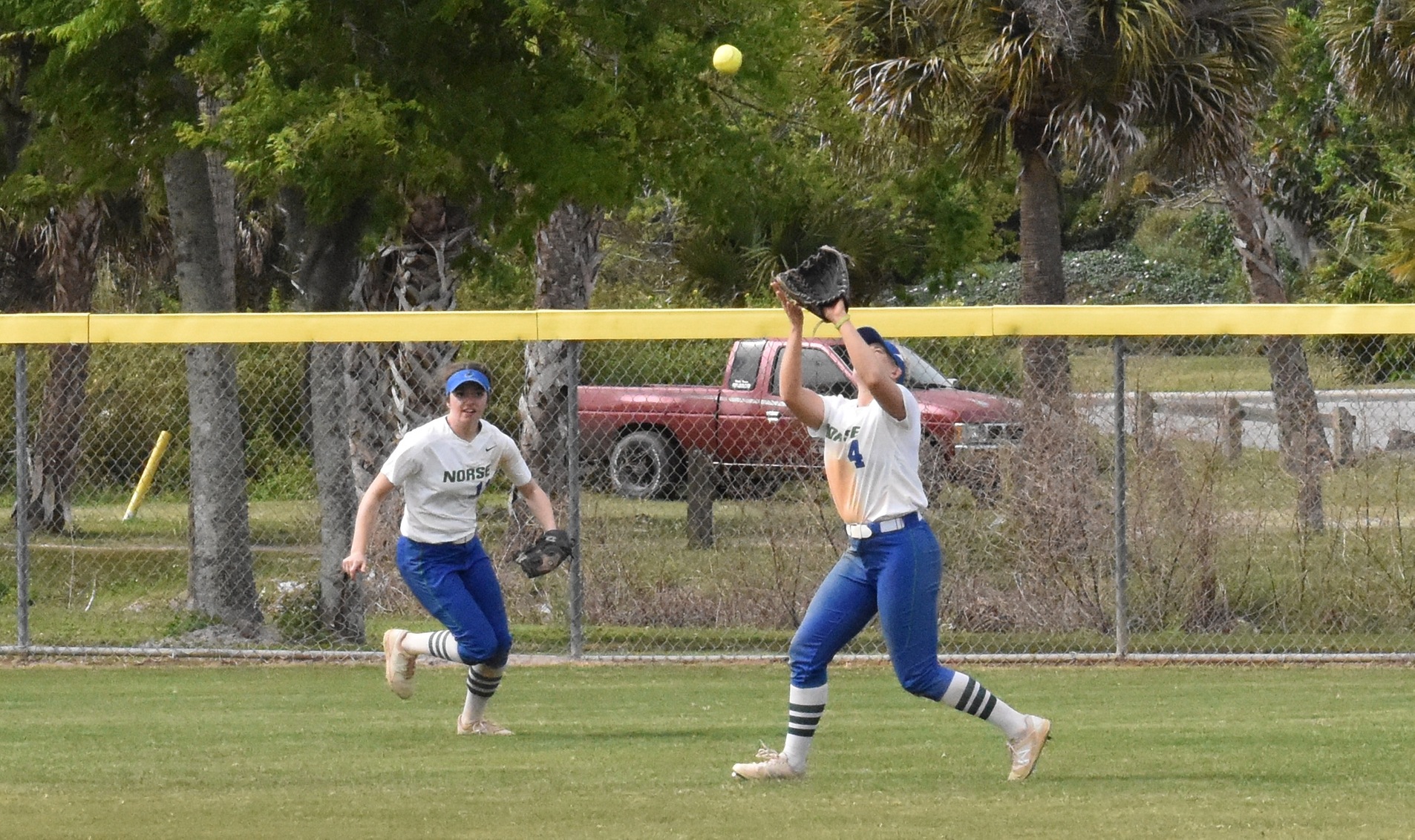 Lexi Chaillier lines up to catch a fly ball in the outfield as Kaitlyn Hardwick looks on