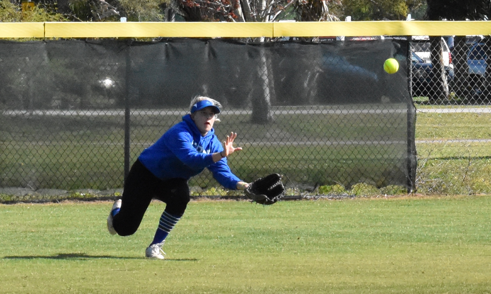 Lexi Chaillier diving for a catch in the outfield