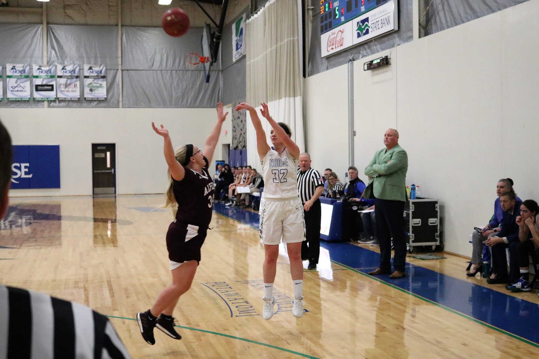 Haley Trudell shooting a three from the wing, a defender closing in