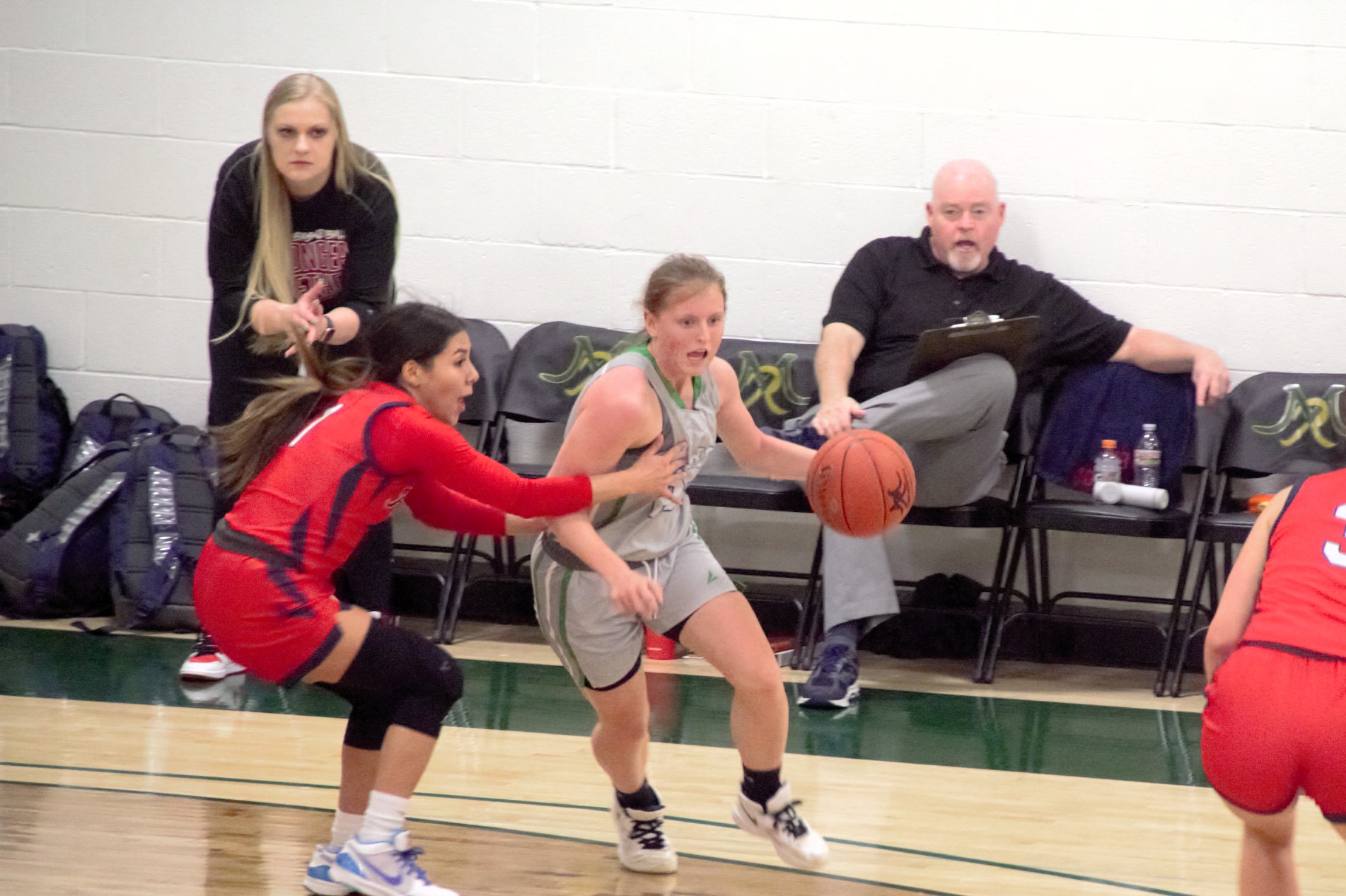 Siena Lingle dribbles around a defender, while the defender tries to hold her back