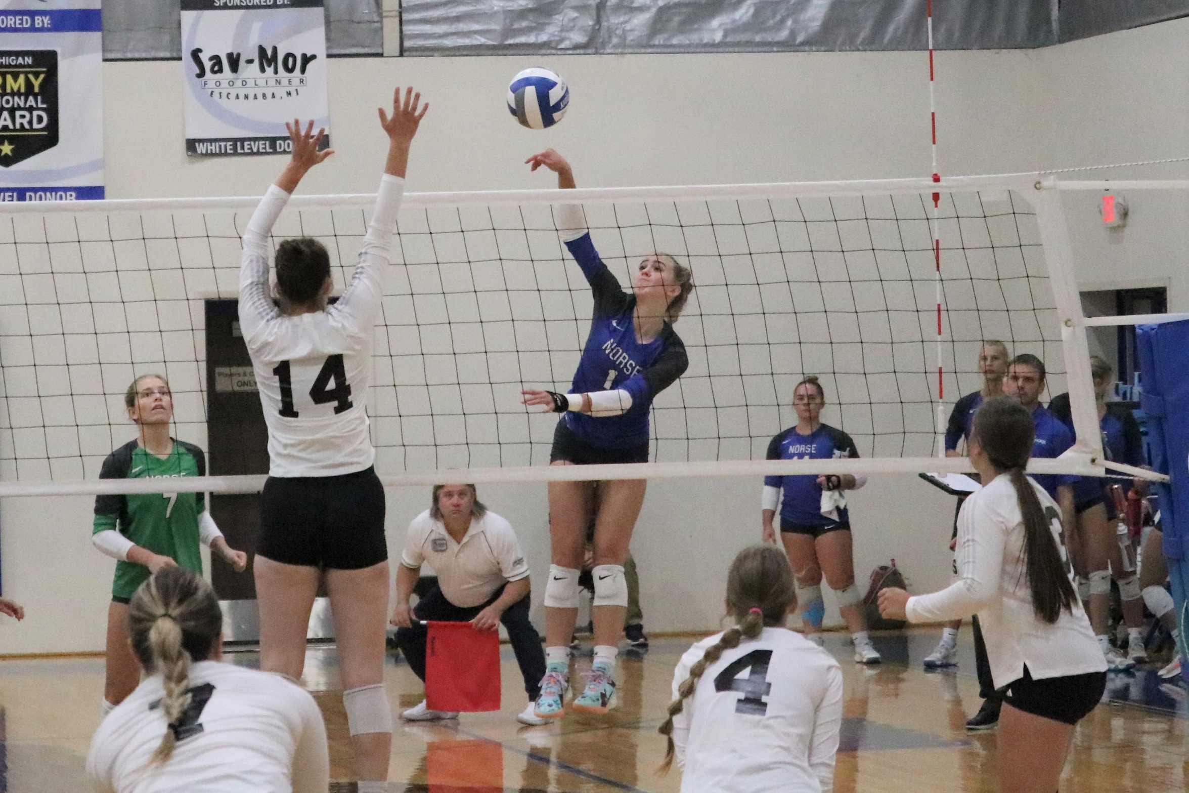 Leah Allan finishing a kill attempt as number 14 from Alpena tries to block it