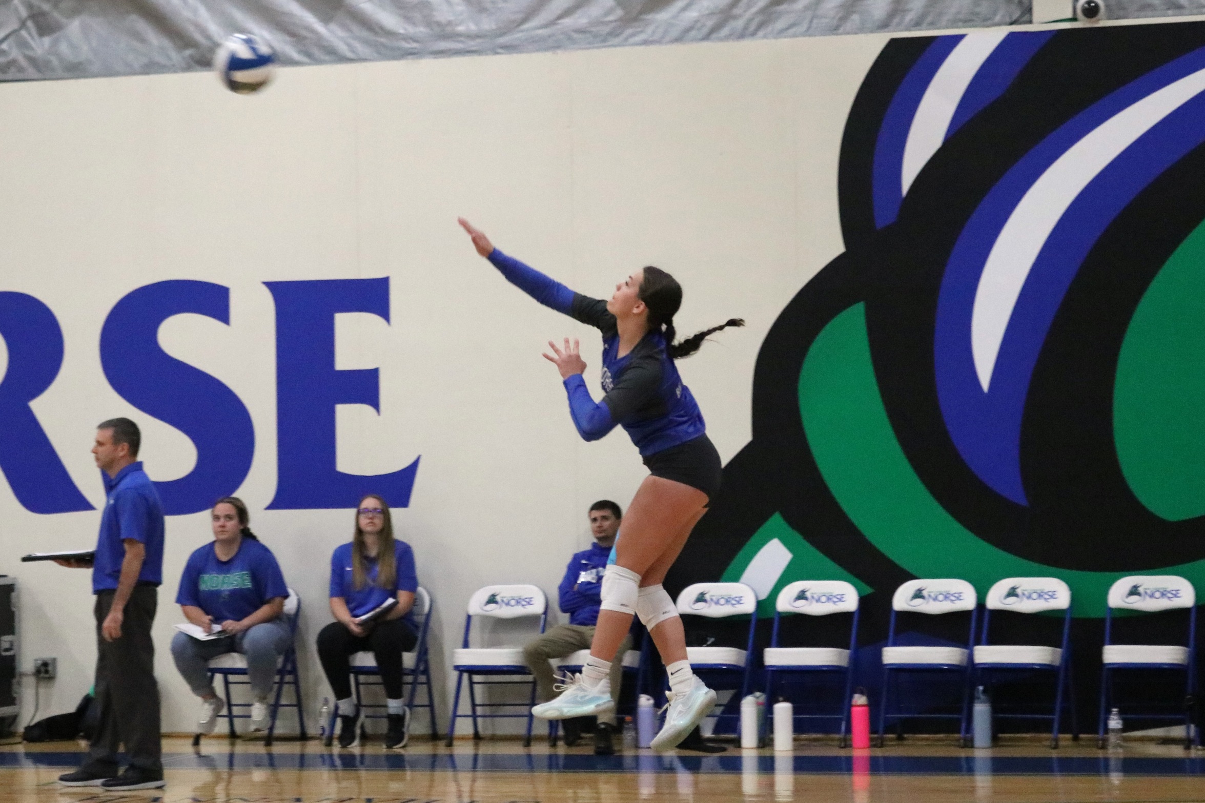 Mia Hauser in mid air, just after contacting a serve